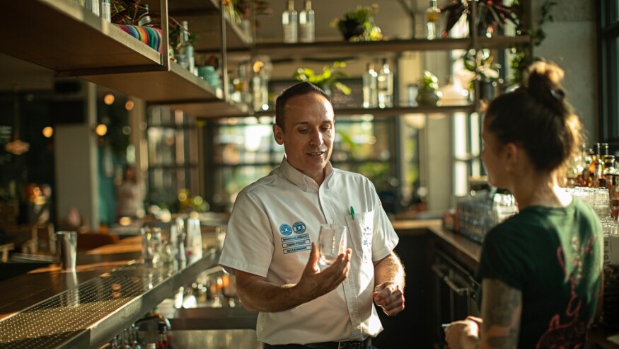 An Ecolab associate talking with a customer at a restaurant.
