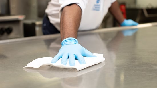 Wiping counter in rubber gloves