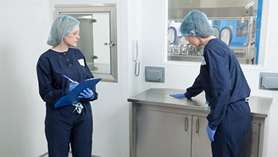 Two technicians cleaning in a cleanroom with Ecolab product