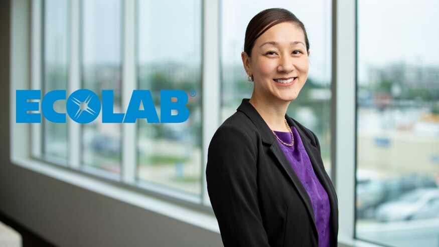 Smiling Ecolab employee next to logo