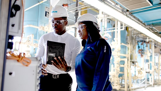 Two Ecolab experts reviewing data on a tablet computer at a power plant
